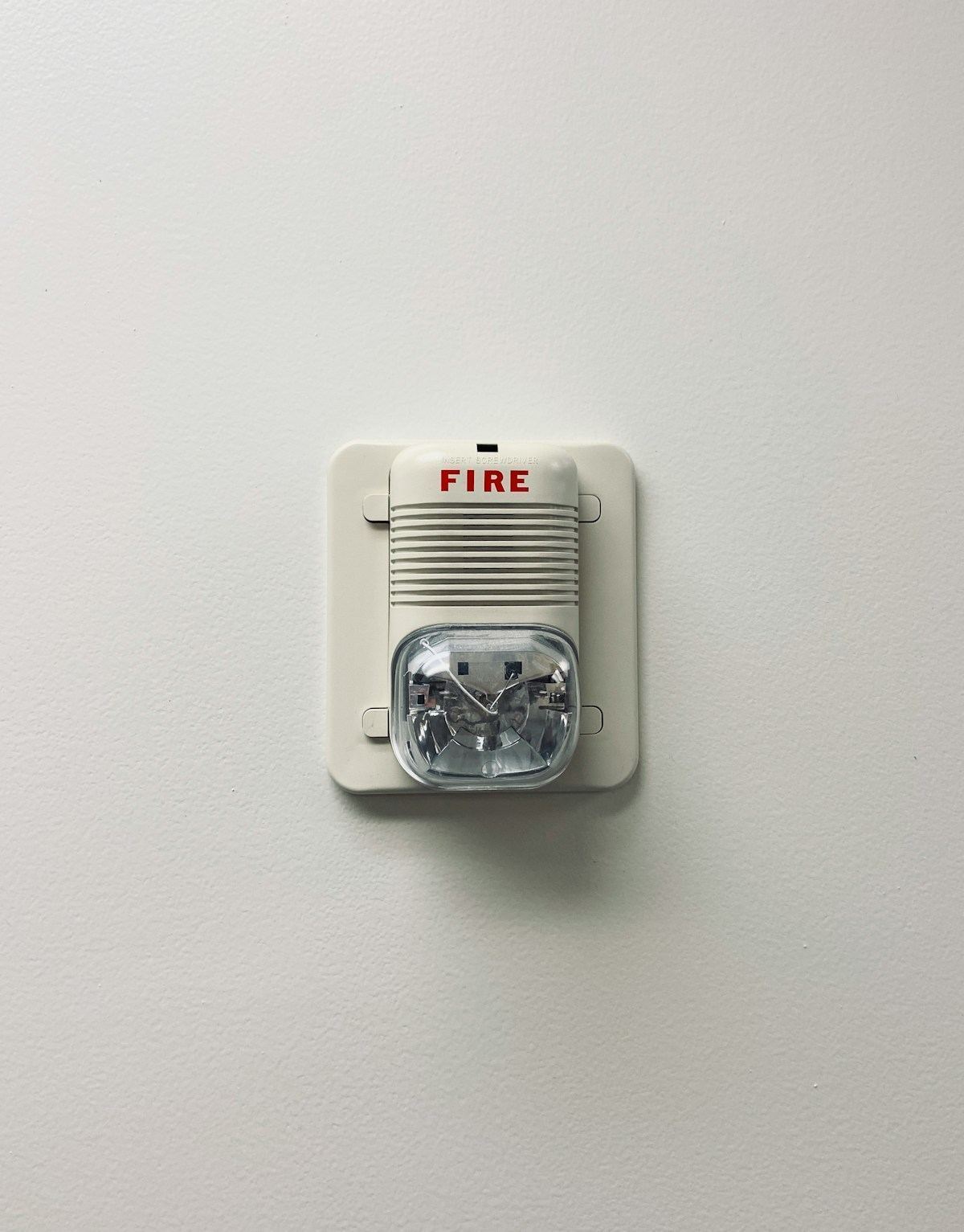 Modern residential smoke detector mounted on a ceiling — the last line of defense against electrical fire