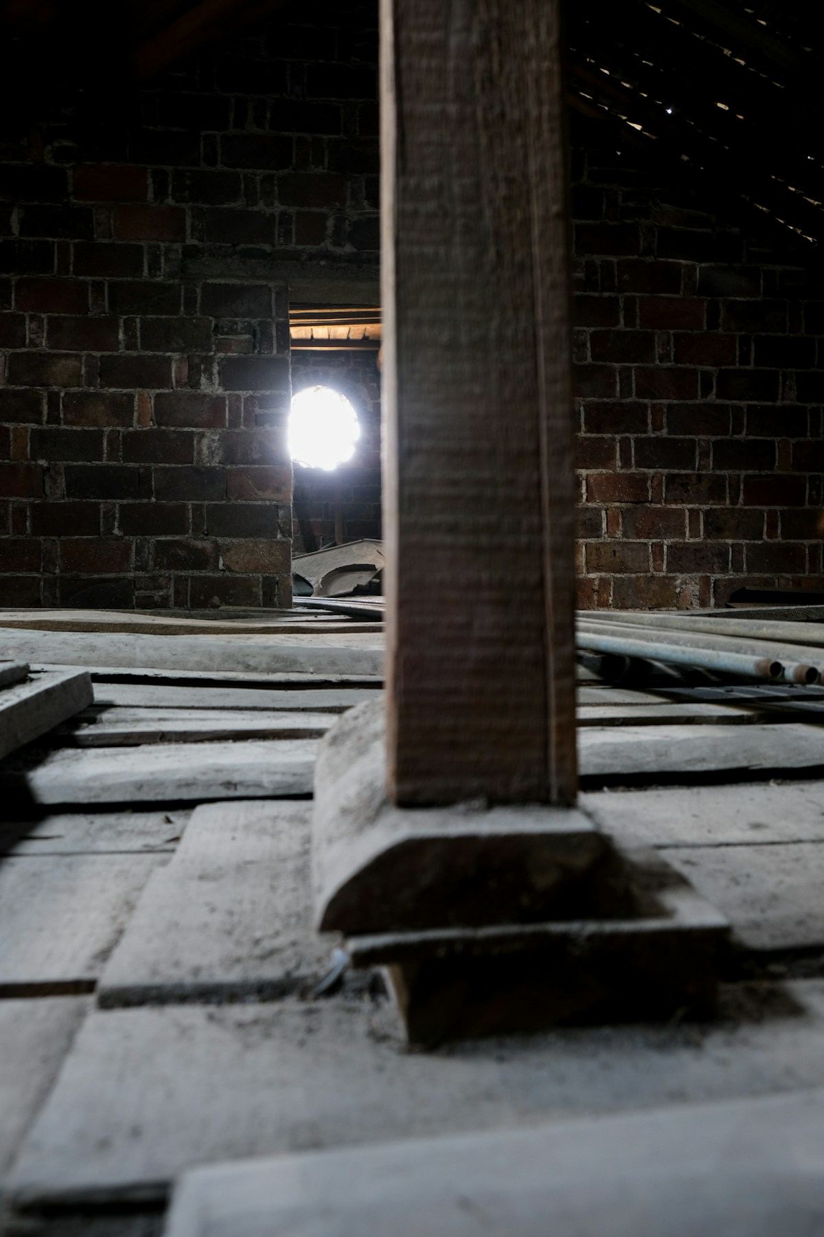 Older home attic with exposed wooden beams — the kind of unfinished space where knob-and-tube wiring is still visible